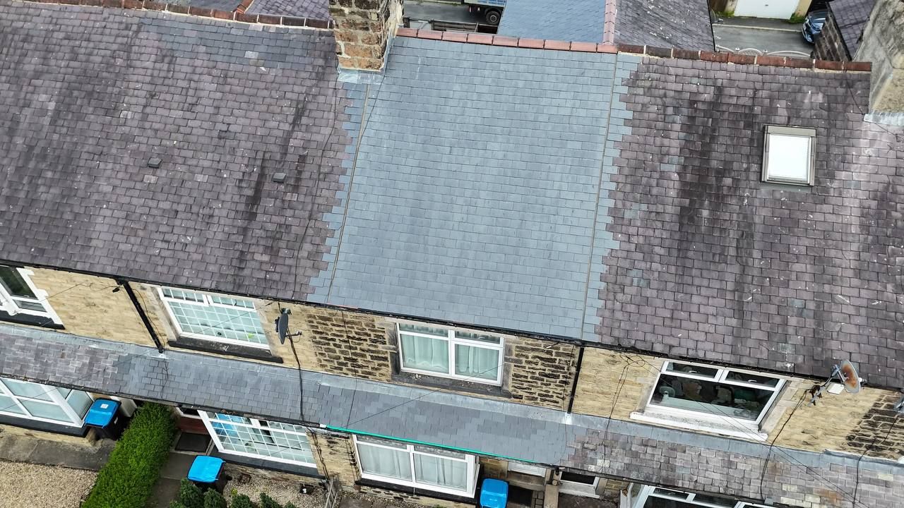 Completed grey tiled hipped roof with scaffolding
